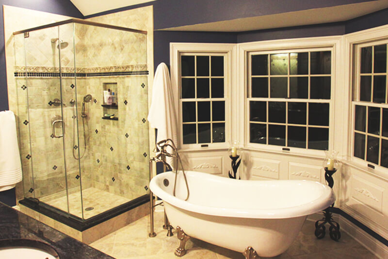 Blue Bathroom with Wrap Around Windows and Freestanding Clawfoot Tub and Glass-Walled Shower