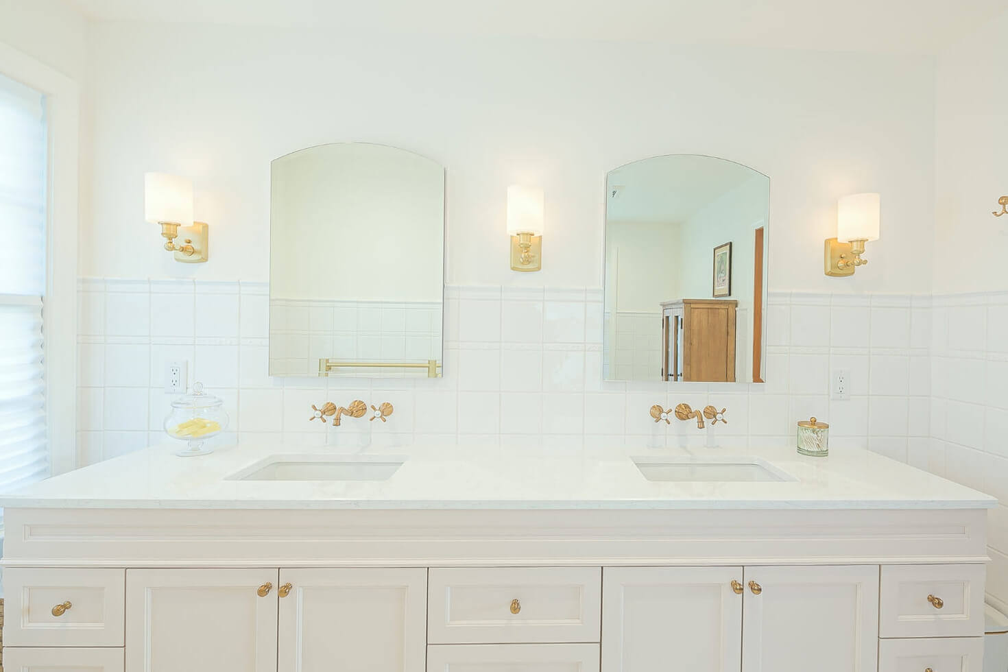dual-sink-bathroom-vanity bathroom remodeling (1) (2) A white double vanity bathroom with brass fixtures and soft lighting.